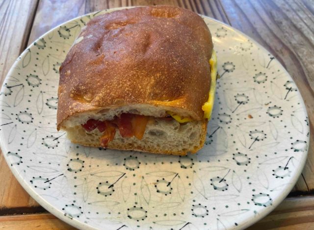 panera bacon egg and cheese on ciabatta sandwich on printed plate.