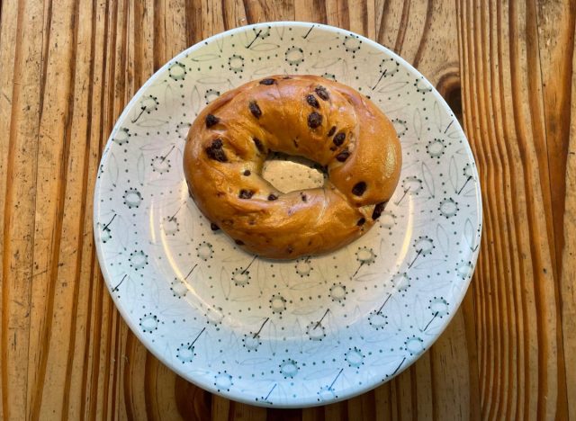 a panera chocolate chip bagel on a printed plate. 