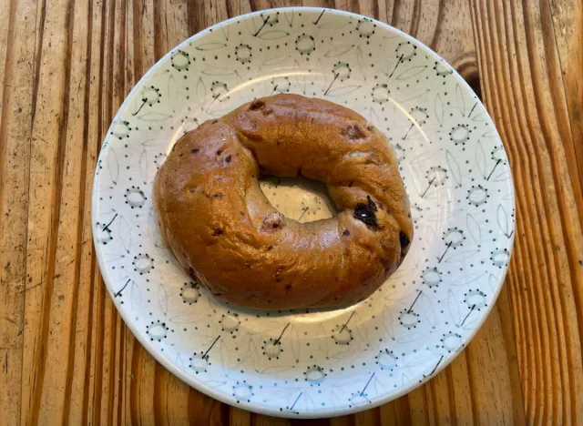 a panera cinnamon bagel on a printed plate. 