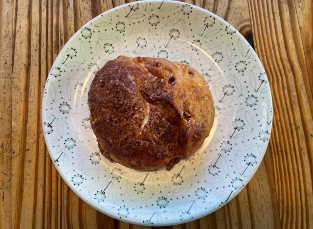 a panera cinnamon crunch bagel on a printed plate. 