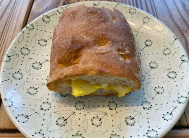 panera egg and cheese on ciabatta sandwich on a printed plate.