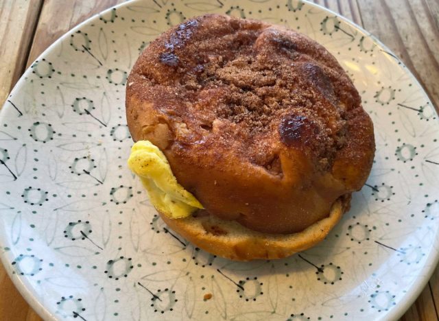 panera ham egg and cheese on a cinnamon crunch bagel on a printed plate.