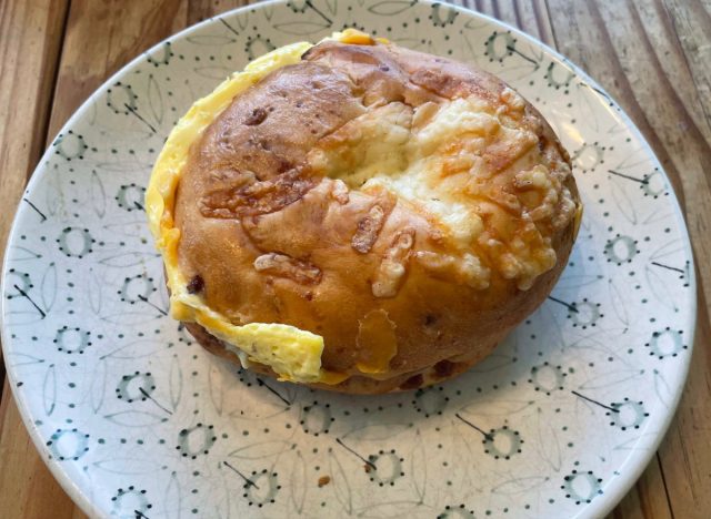 panera sausage egg cheese asiago sandwich on a printed plate.