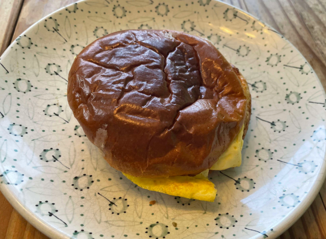 panera sausage egg cheese brioche sandwich on a printed plate. 