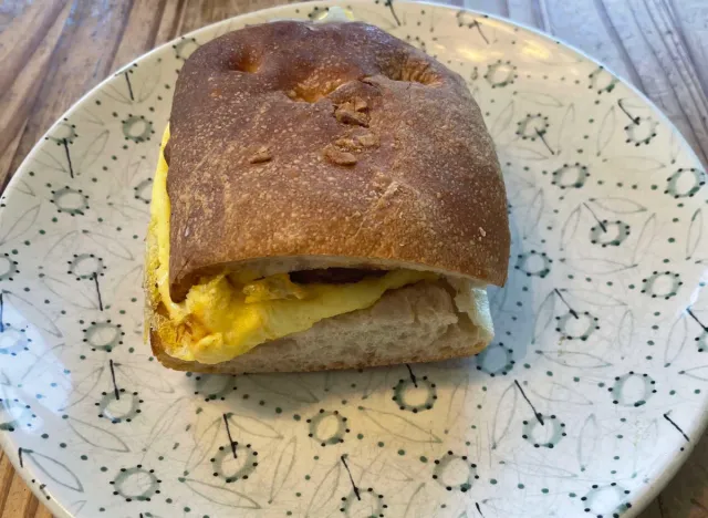 panera sausage scrambled ciabatta sandwich on a printed plate. 