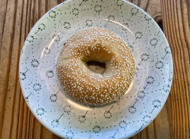 a panera sesame bagle on a printed plate. 