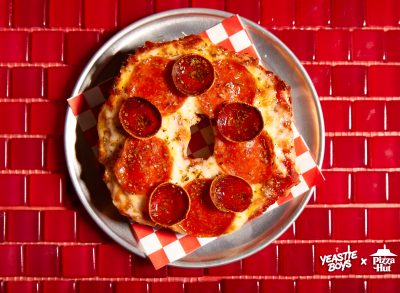 pizza hut's big new yorker pizza bagel on plate against red tiled background