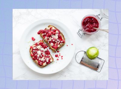 raspberry almond butter toast on white plate with mason jar of jam next to the plate