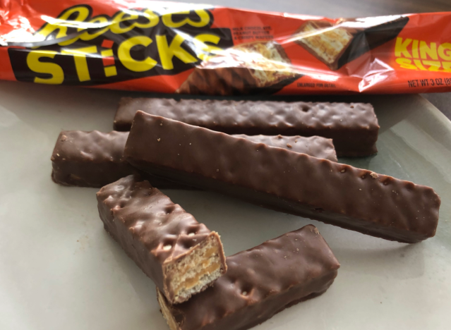 reeses sticks broken up and in front of a wrapper.