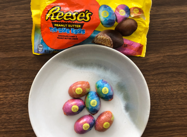 reeses tie dye eggs in colorful foil wrappers on a plate.