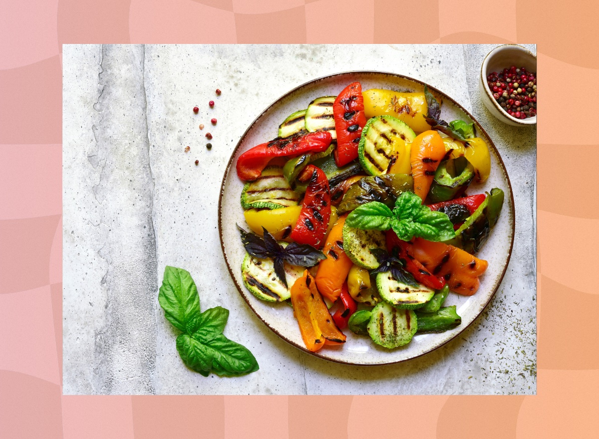 colorful roasted vegetables on a plate with small bowl of pepper on the side