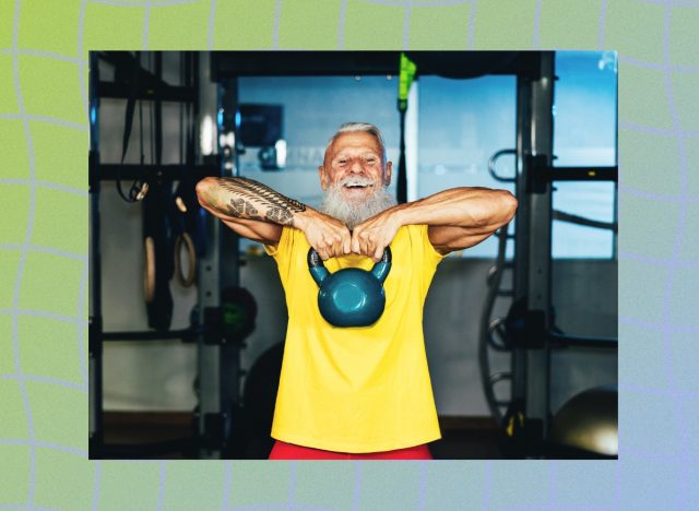 happy senior man with gray hair and bright yellow t-shirt lifting kettlebell at the gym