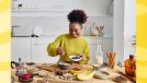 a woman cooking healthy food on a yellow background