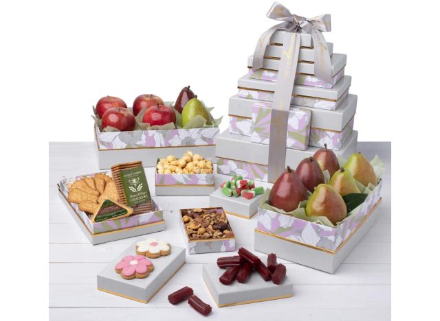 gift box tower next to open boxes filled with apples, pears, crackers, and nuts, plus licorice and flower-shaped cookies