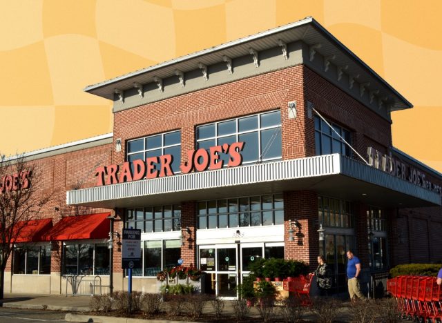 Trader Joe's storefront with carts and trees in the front in front of orange yellow backdrop design