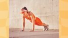 fit woman in orange workout attire and orange visor doing pushups outdoors on cement