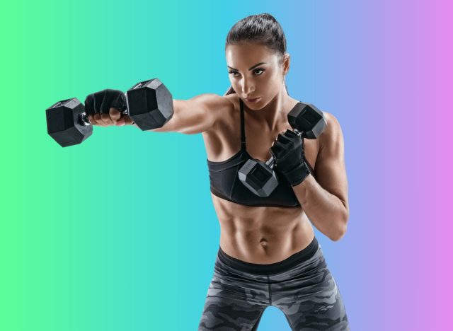 fit, muscular woman doing dumbbell exercise in front of muti-colored backdrop