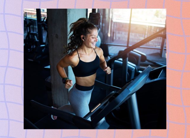 fit, happy woman running or sprinting on the treadmill at the gym next to a big window