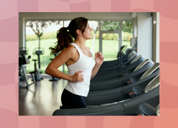 fit brunette woman running on treadmill in front of windows at the gym