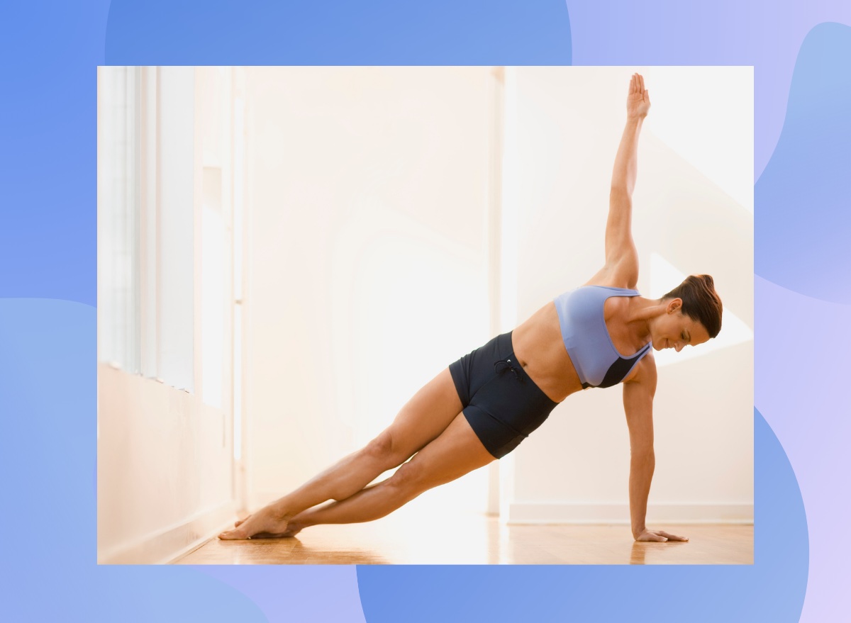 fit woman doing side plank exercise at home in a bright room