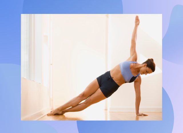 fit woman doing side plank exercise at home in a bright room