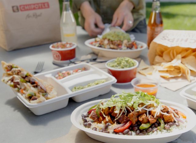 An assortment of Mexican-inspired food items from Chipotle arranged on a picnic table