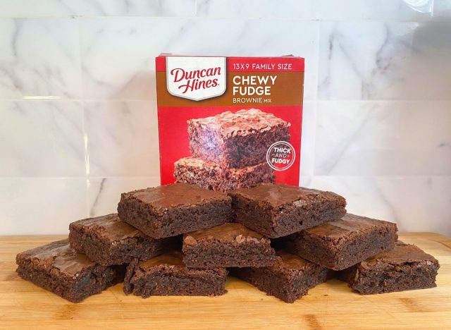 Duncan Hines Chewy Fudge brownies and box on a wooden cutting board