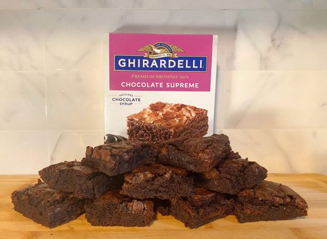 Ghirardelli Chocolate Supreme brownies and box on a wooden cutting board