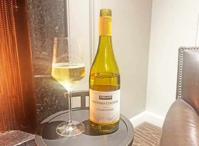 Costco's Kirkland Signature chardonnay bottle and glass on table.