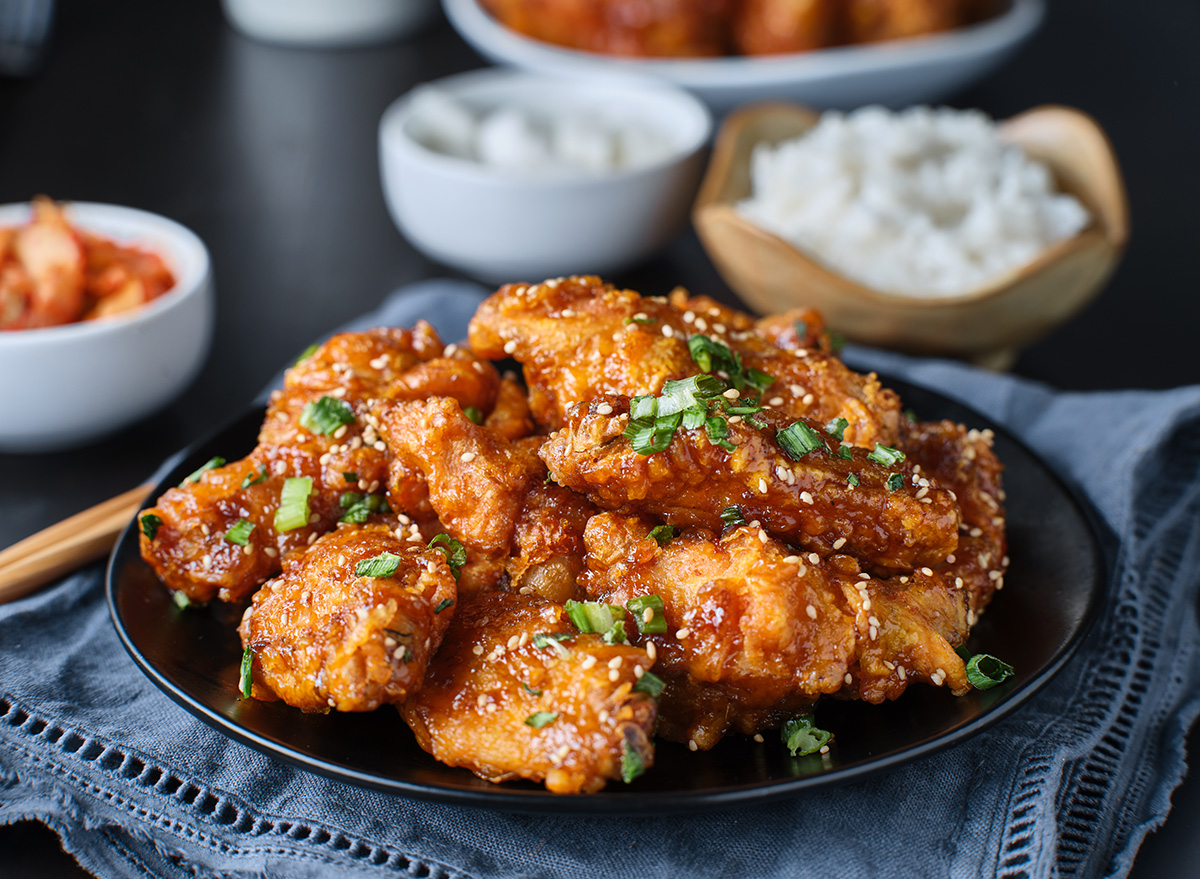 crispy fried korean chicken wings in galbi sauce with pickled radish, kimchi, and rice side dishes