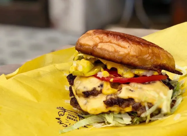 Burger from La Lucha atop a yellow wrapper