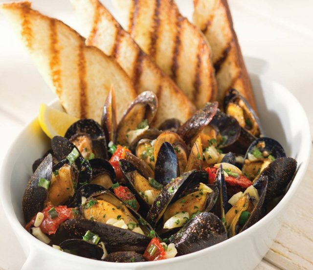 red lobster mussels in a bowl with toasted bread.