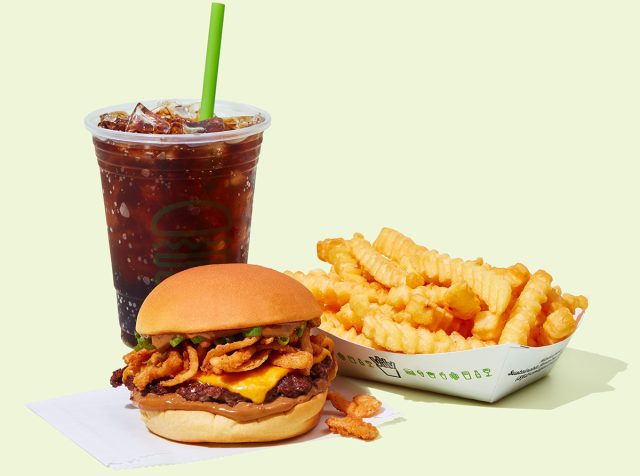 Shake Shack's Korean BBQ Burger with fries and a drink against a colorful background