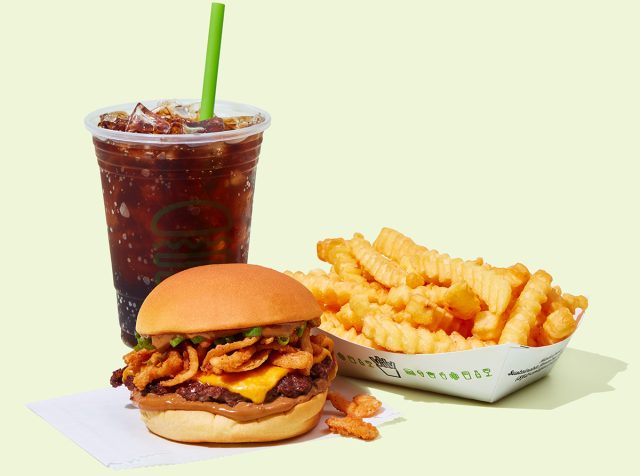 Shake Shack's Korean BBQ Burger with fries and a drink against a colorful background