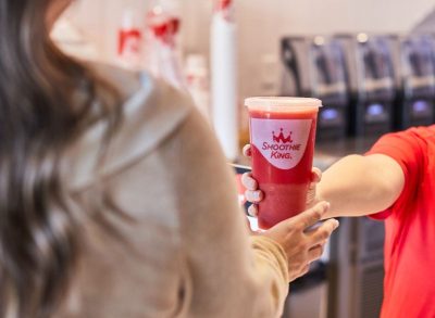Smoothie King worker handing cup to customer