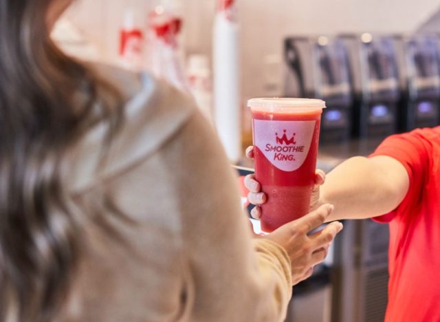 Smoothie King worker handing cup to customer