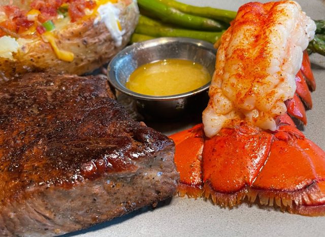 Steak & lobster, served with a stuffed potato and green beans, at Outback Steakhouse