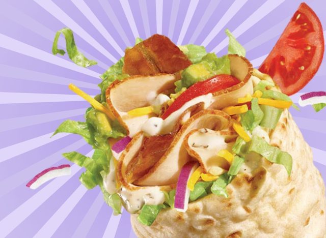A closeup of the new Turkey, Bacon & Avocado flatbread wrap at Subway, against a colorful background.