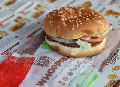 A Burger King Whopper sandwich atop its wrapper