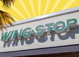 The storefront of a Wingstop restaurant against a colorful background