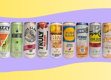 a photo of nine popular hard seltzer cans in a line on a wavy yellow and purple designed background