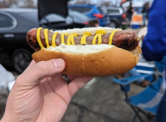 a hand holding a bratwurst from a brewers game.