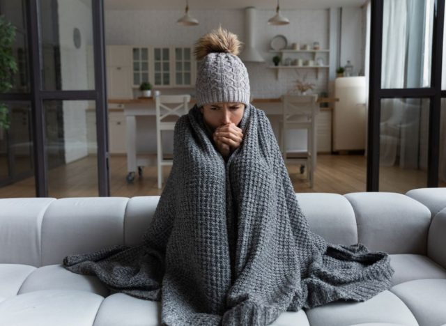 woman shivering under a blanket