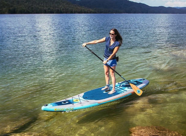 a woman using a paddle board.
