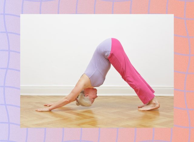 mature woman in purple and pink flowy yoga attire doing downward-facing dog