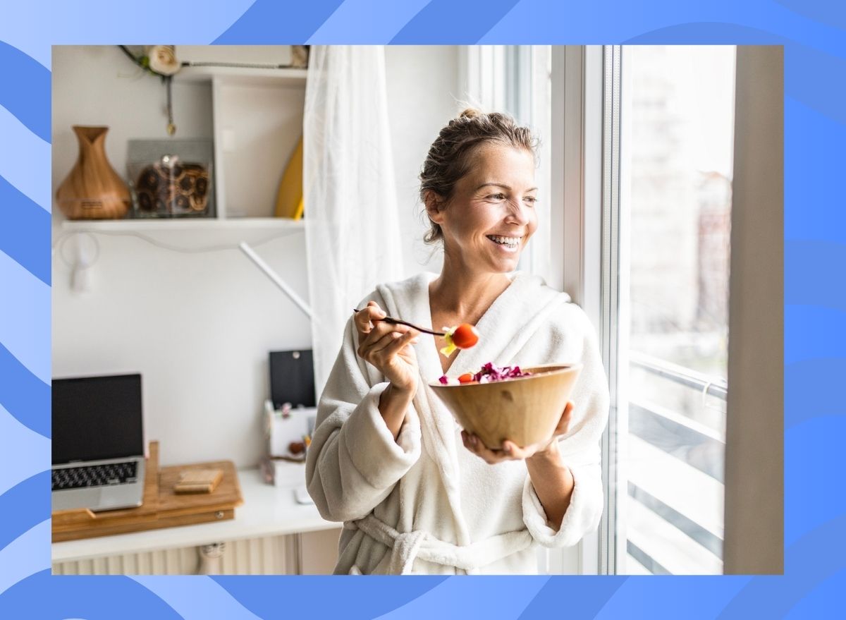 woman eating vegetables in a kitchen