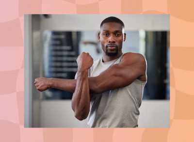 fit, muscular man wearing gray tank top stretching at the gym