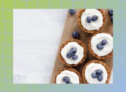 healthy mini blueberry dessert tarts on serving board with fresh blueberries
