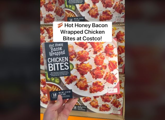 person holding box of hot honey bacon wrapped chicken bites