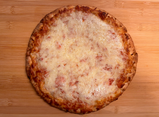 a cheese pizza on a cutting board. 